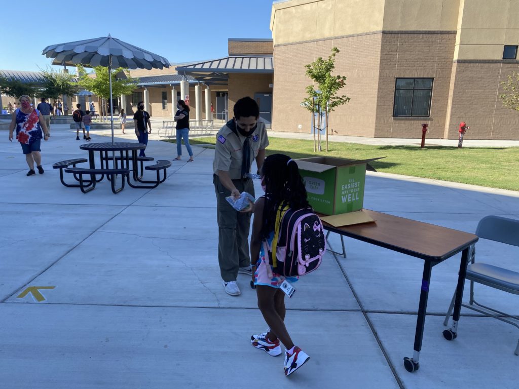 Julian Handing out a mask to a student. 